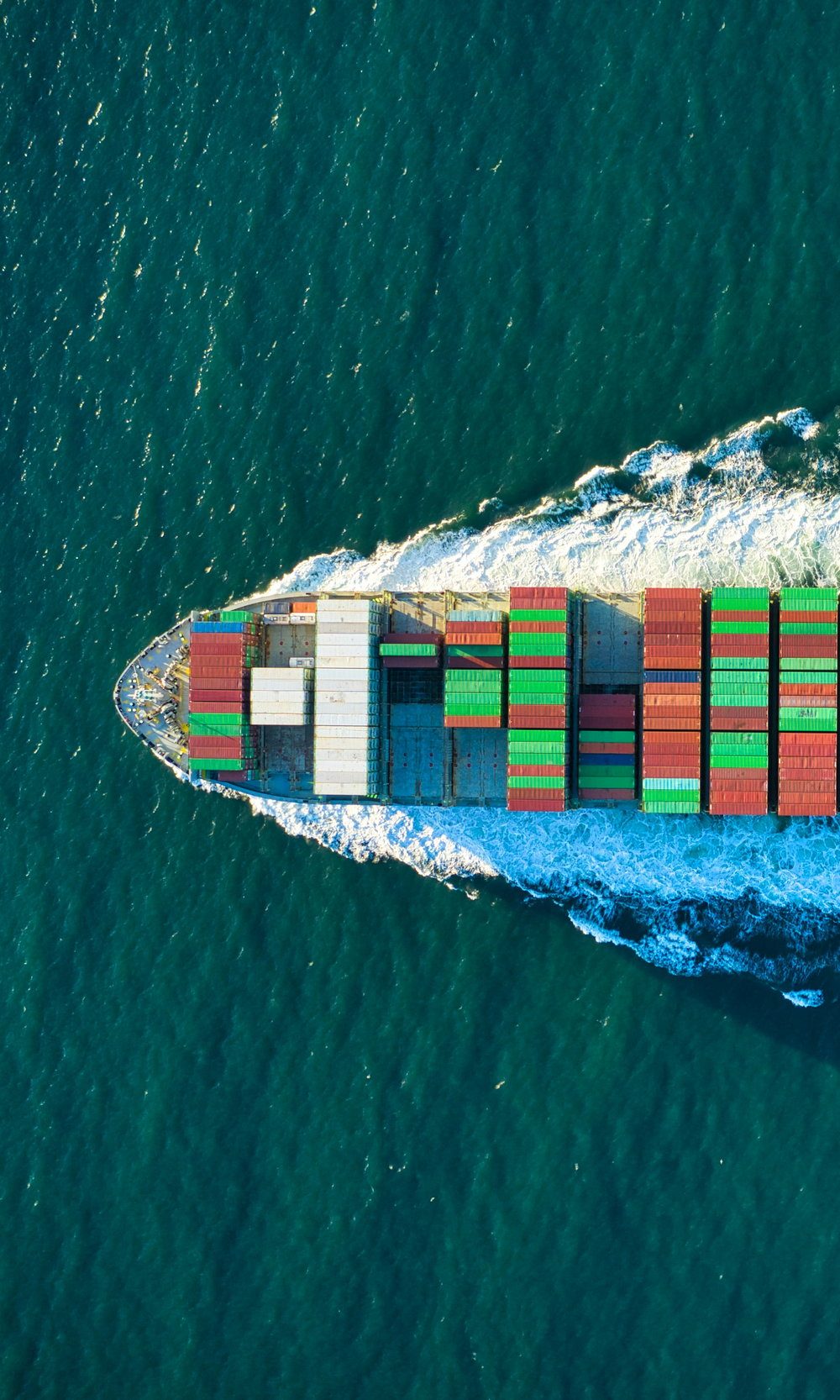 Bow of a container ship seen from above, with its wake